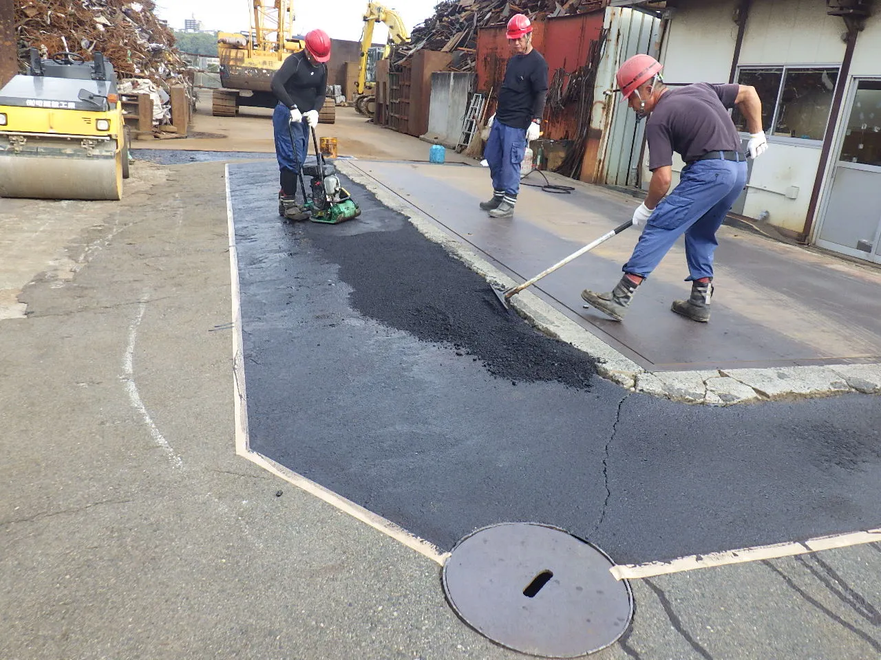 工場内の段差を舗装で整える作業風景
